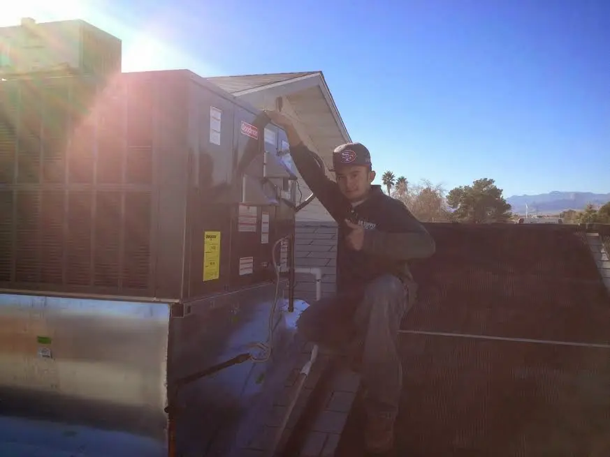 HVAC technician performing Heat Pump Repair on a rooftop unit in New Albany